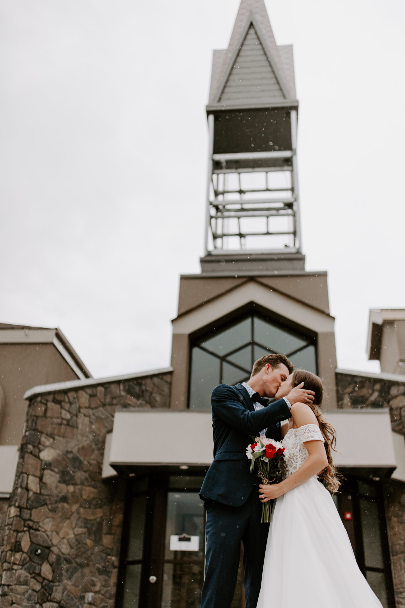 couple kissing in front of church in Canmore